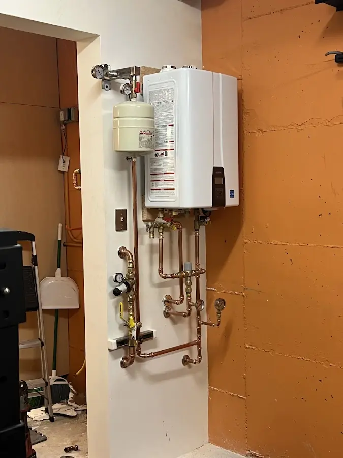 Plumbing technician inspecting water heater connections in South Barrington